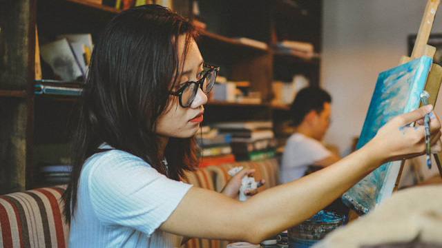 a girl painting on a canvas